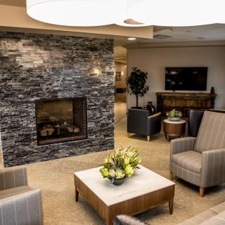 Modern lobby with a cozy seating area and a stone fireplace.