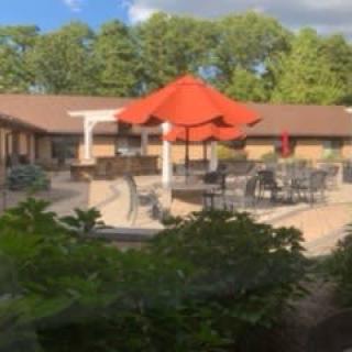 Outdoor patio with red umbrellas and seating.