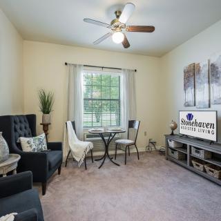 A cozy living room with a small dining set, comfortable seating, and a TV stand.