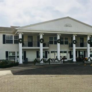 A large white building with columns and festive wreaths on the facade.