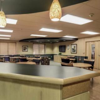 A spacious cafeteria with modern lighting and furniture.