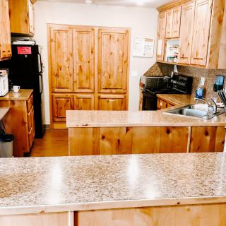 A spacious kitchen with wooden cabinets and modern appliances.