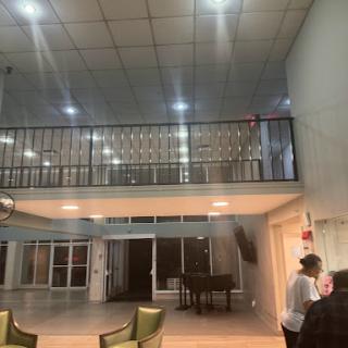 A spacious living room featuring a balcony with modern lighting and furniture.