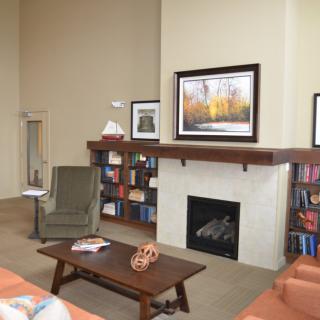 A cozy living room with a fireplace, bookshelves, and comfortable seating.