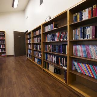 A quiet library aisle lined with bookshelves filled with various books.