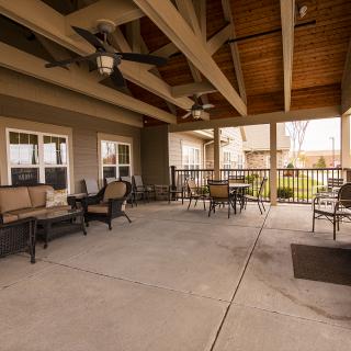 A spacious outdoor patio with comfortable seating and ceiling fans.