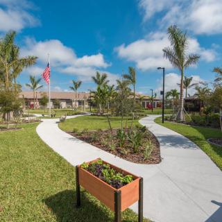 A beautifully landscaped garden with winding pathways and lush greenery under a clear blue sky.