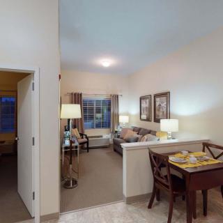 A cozy apartment living room with modern furniture and warm lighting.