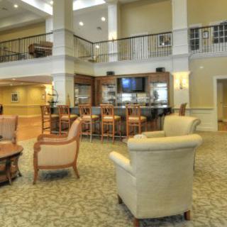 A spacious and modern lobby area with comfortable seating and a bar.
