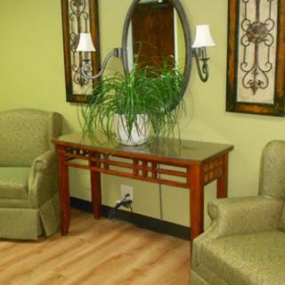 A cozy living room setup with two chairs, a table, and decorative elements on the wall.
