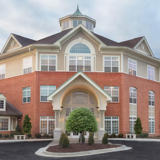 A beautifully designed residential building with a charming entrance and large windows.