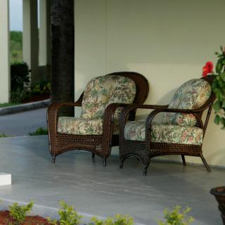 A cozy patio setup with wicker chairs and floral cushions on a porch.