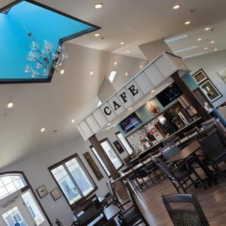 A modern cafe interior featuring a skylight and elegant chandelier.