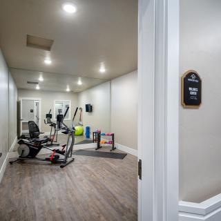 A home gym with various exercise equipment including a treadmill and an exercise bike.