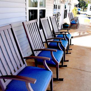 A row of stylish outdoor chairs with blue cushions, perfect for enjoying a sunny day.