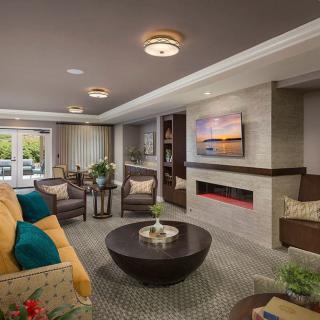 A modern and cozy living room with comfortable seating, a fireplace, and a mounted television.