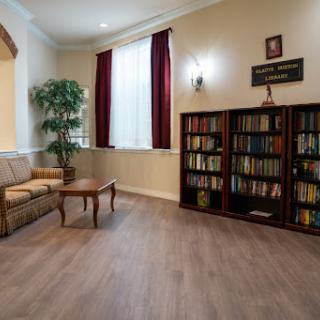 A cozy living room featuring a bookshelf filled with books, a comfortable sofa, and warm lighting.