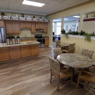 A cozy kitchen and dining area with wooden cabinets and round table.