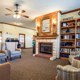 Cozy living room with a fireplace, bookshelves, and comfortable seating.