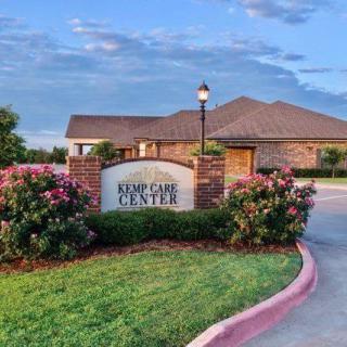 A building with a well-manicured garden and a sign reading 'EMPCARE CENTER' at the entrance.