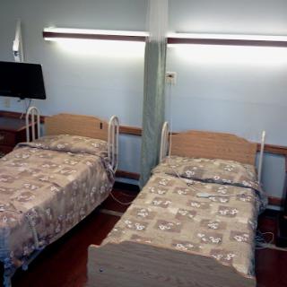 A view of a hospital patient room featuring two beds.