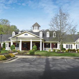 A picturesque residential building with well-maintained landscaping in a suburban setting.