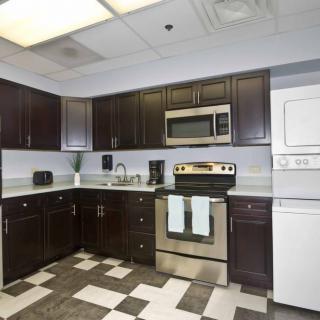 Modern kitchen with dark cabinets and stainless steel appliances.