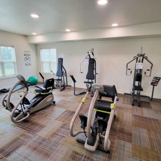 A well-equipped gym room with various exercise machines for fitness enthusiasts.