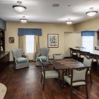 A cozy living room with comfortable seating, a table, and ample lighting.