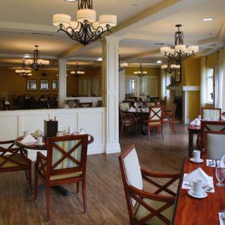 Elegant restaurant dining area with wooden floors and stylish chandeliers.