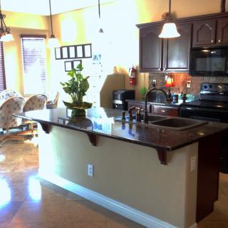 A modern kitchen with a central island and attached dining area.