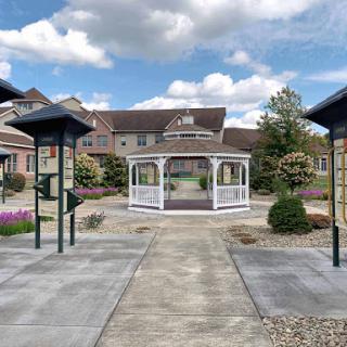 A serene garden featuring a central gazebo surrounded by well-maintained pathways and landscaping.