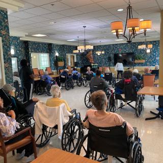 Residents of a nursing home participating in an activity in the common area.