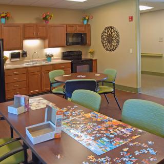A cozy kitchenette and dining area with a partially completed puzzle on the table.