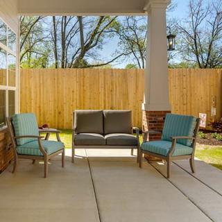 A cozy outdoor patio with comfortable seating and a view of the backyard.