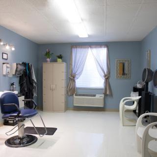 A cozy salon interior featuring blue walls and modern furniture.