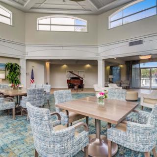 A spacious and inviting lounge area featuring a piano, comfortable seating, and abundant natural light.