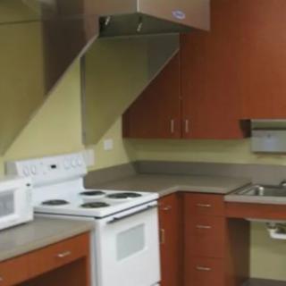 A modern kitchen featuring a stove, microwave, and wooden cabinets.