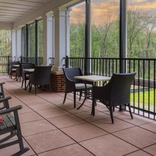 A serene patio with chairs and tables overlooking a lush landscape.