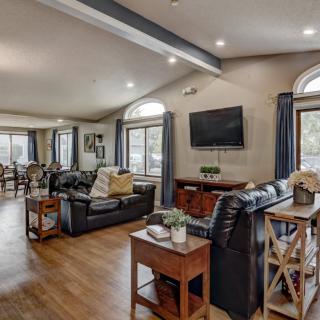 A spacious open-plan living room with modern decor, featuring a kitchen and dining area.