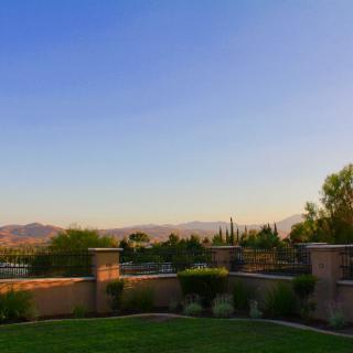 A serene landscape view during sunset with a clear sky and distant mountains.