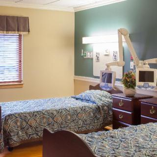 A cozy bedroom with two single beds and a window letting in natural light.