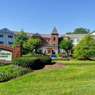 A residential building with well-maintained landscaping and a sign out front.