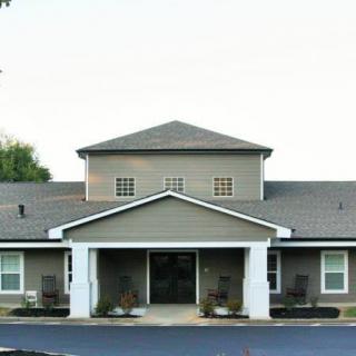 A view of a residential building entrance with a gabled roof and symmetrical design.