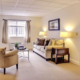 A cozy and well-lit living room with comfortable furniture and elegant decor.