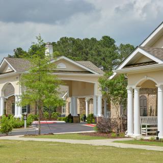 A scenic view of residential buildings with lush greenery and a spacious lawn.