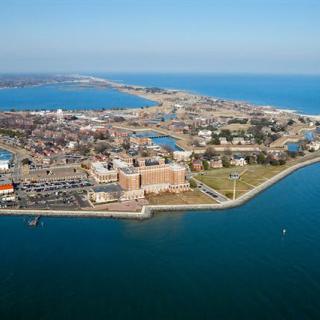 Aerial view of a coastal city with a harbor and buildings along the shoreline.