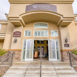 The entrance to a commercial building with wide stairs and large doors.