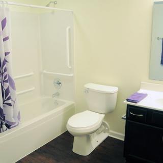 A neatly organized bathroom with a toilet, bathtub, and sink.