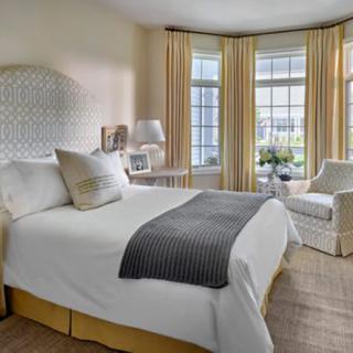 A cozy and elegantly designed bedroom with large windows and soft lighting.